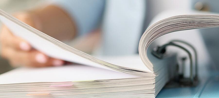 eine Person blättert in einem Aktenordner